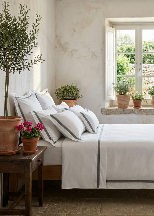 Cozy bedroom with a bed, side table, and potted plants.