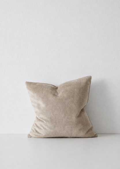 Beige pillow on a white surface with a white background