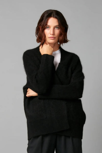 Woman wearing a black sweater against a gray background