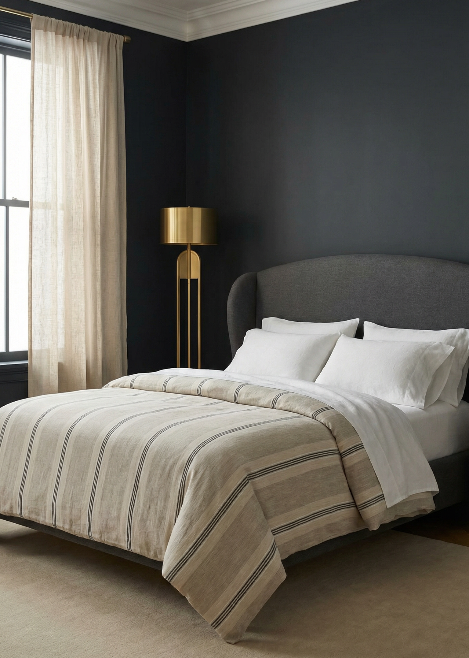 Modern bedroom with dark walls, a bed with striped bedding, and a standing lamp.