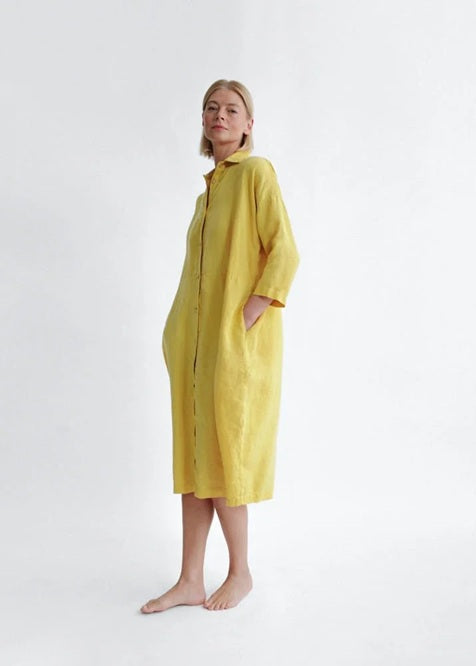 Person wearing a yellow dress against a white background