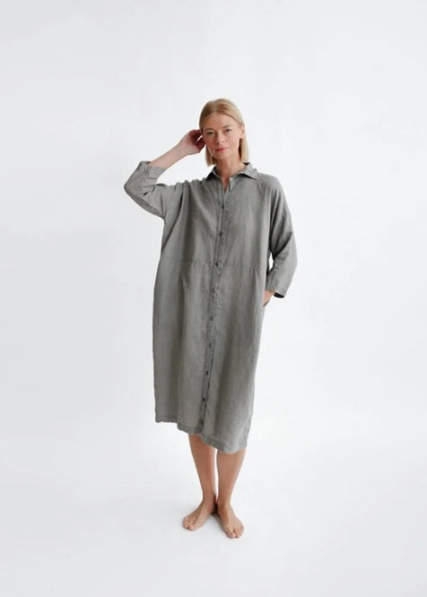 Woman wearing a gray shirt dress on a white background
