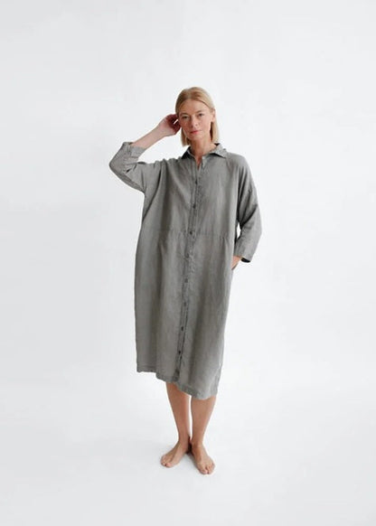 Woman wearing a gray shirt dress on a white background