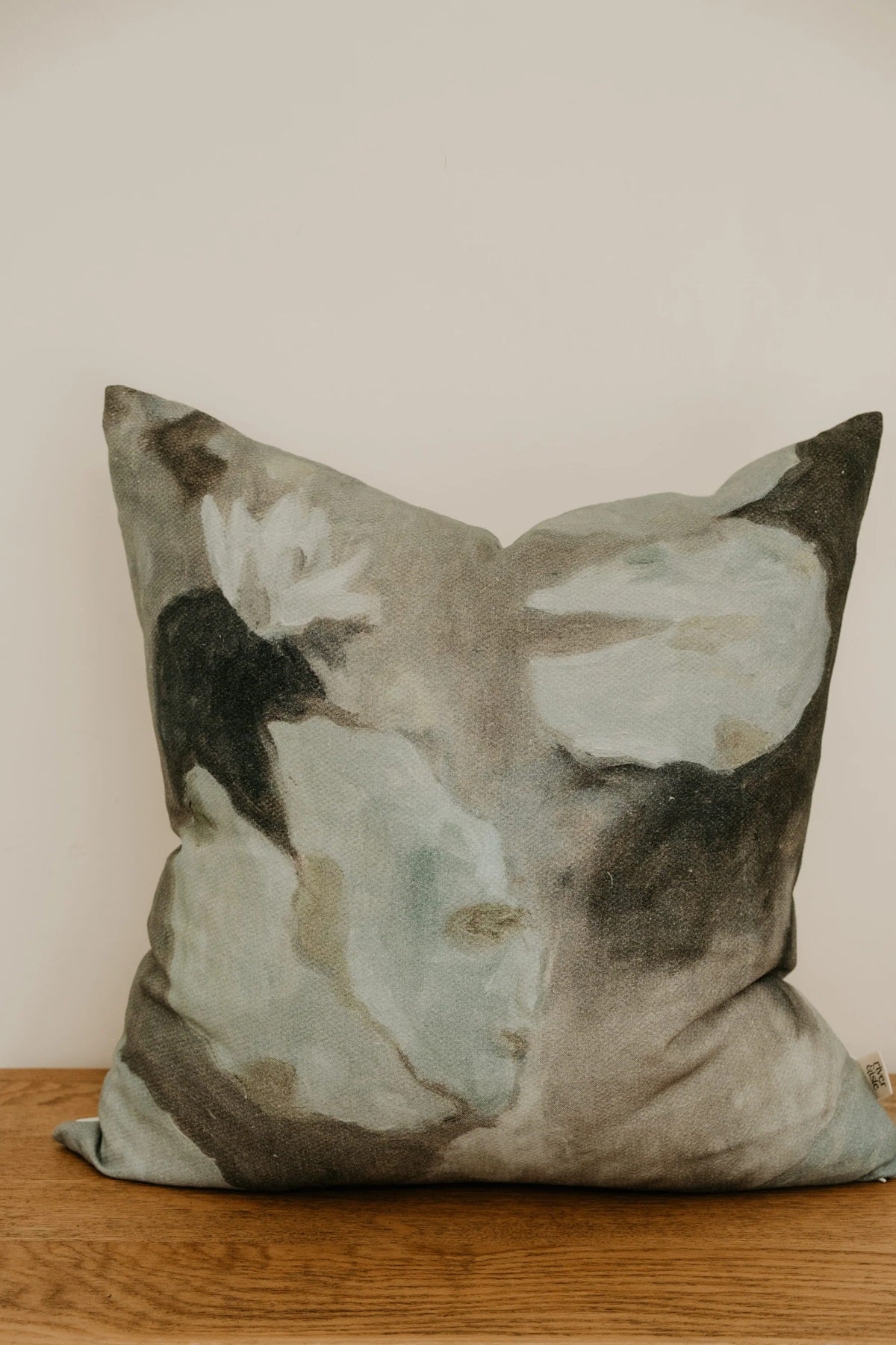 Decorative pillow with abstract pattern on a wooden surface