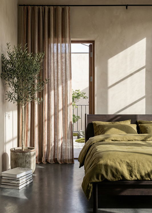 Modern bedroom with green bedding, large window, and decorative plants.