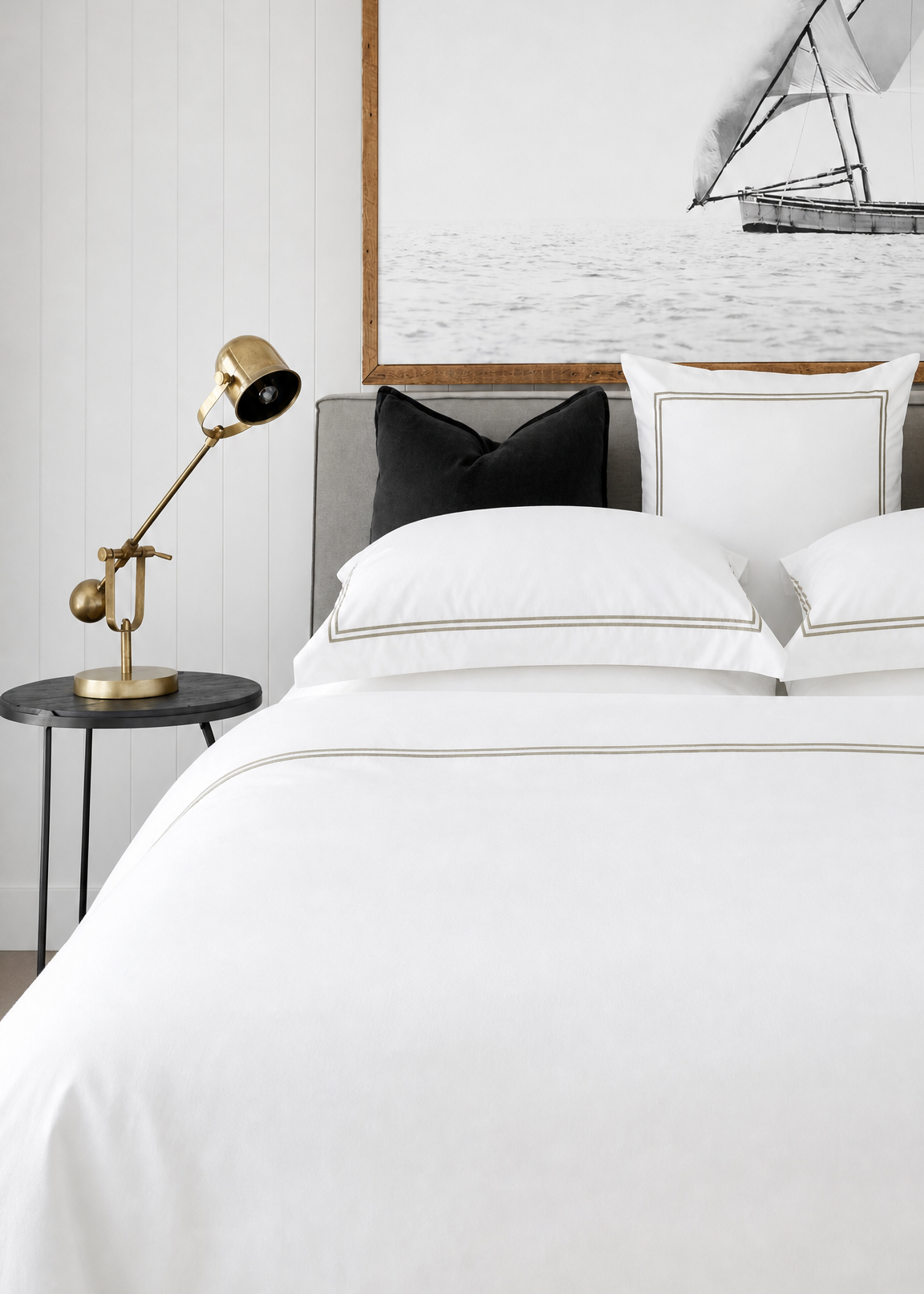 Neatly made bed with white bedding in a bedroom setting.