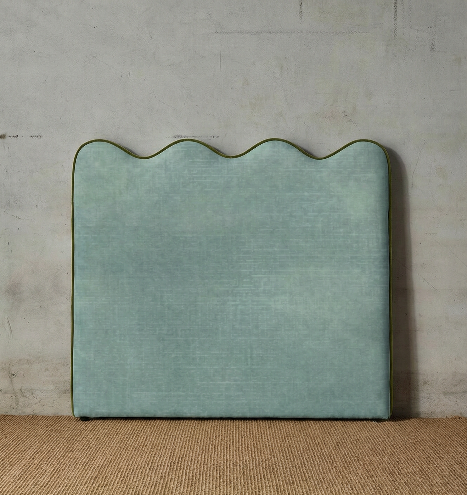 Green textured headboard against a neutral wall