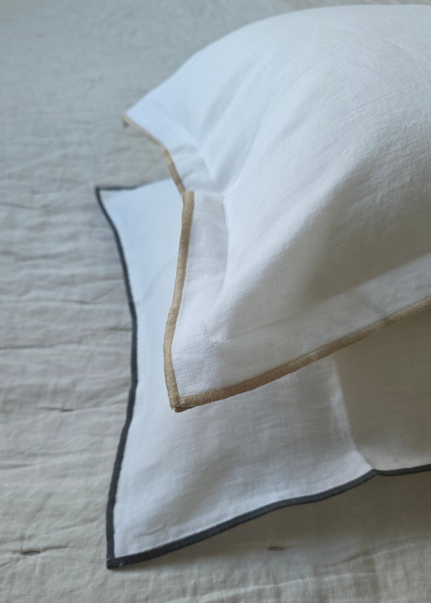 White fabric with black and gold trim on a textured surface