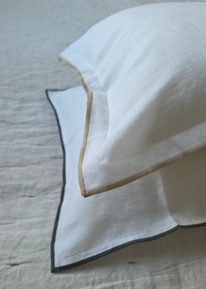White fabric with black and gold trim on a textured surface