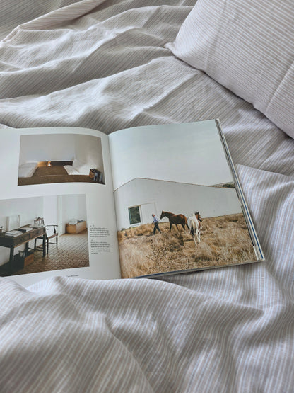 Open book on a textured surface with images of horses and rooms.