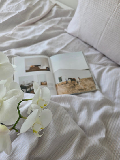 White orchids on a white textured fabric background
