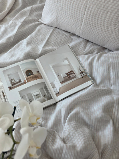 Open book on a bed with white orchids