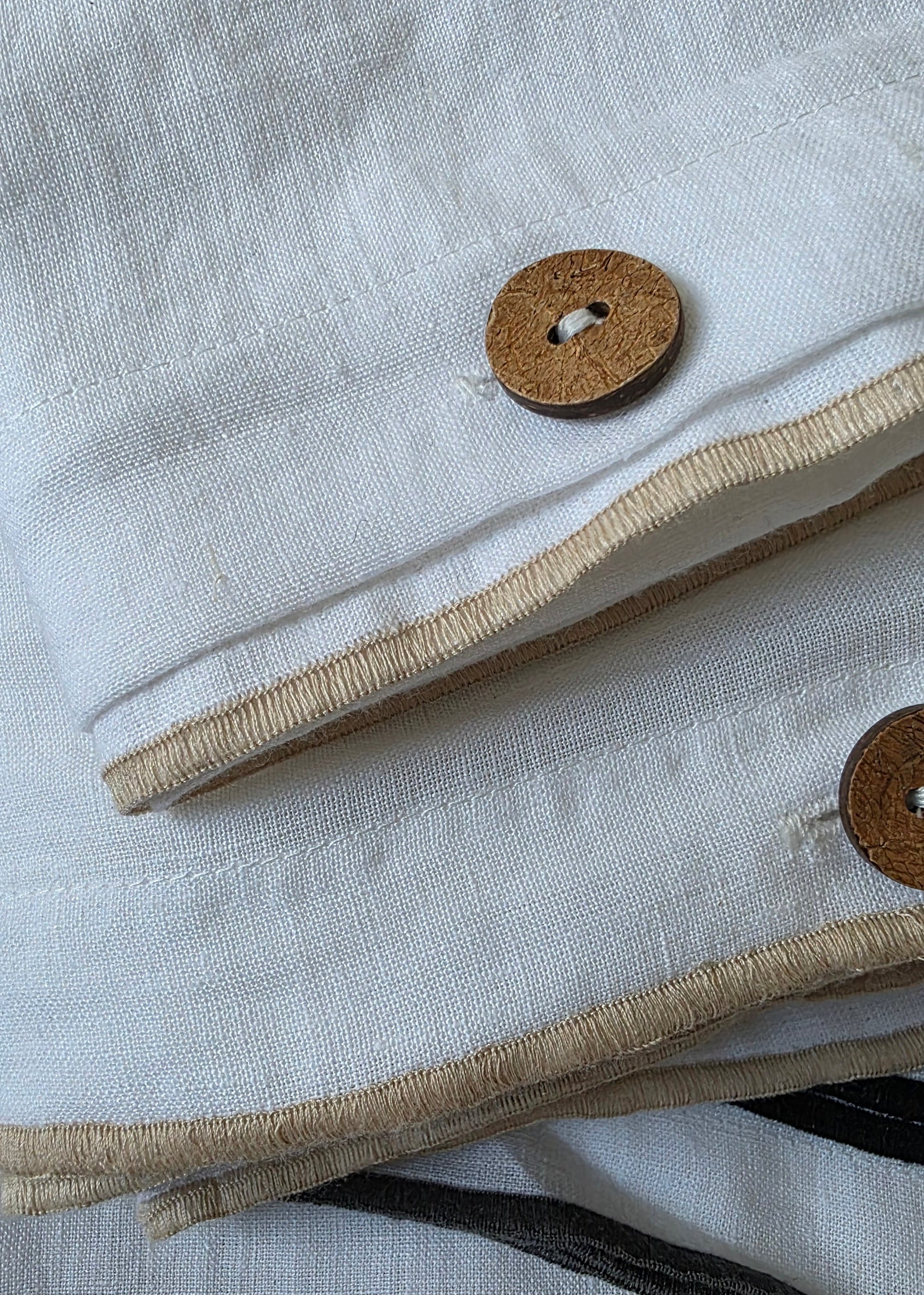 Close-up of a textured fabric with buttons and a striped pattern