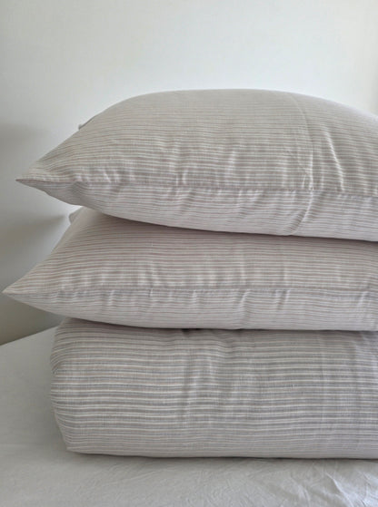 Stack of striped pillows on a light gray background