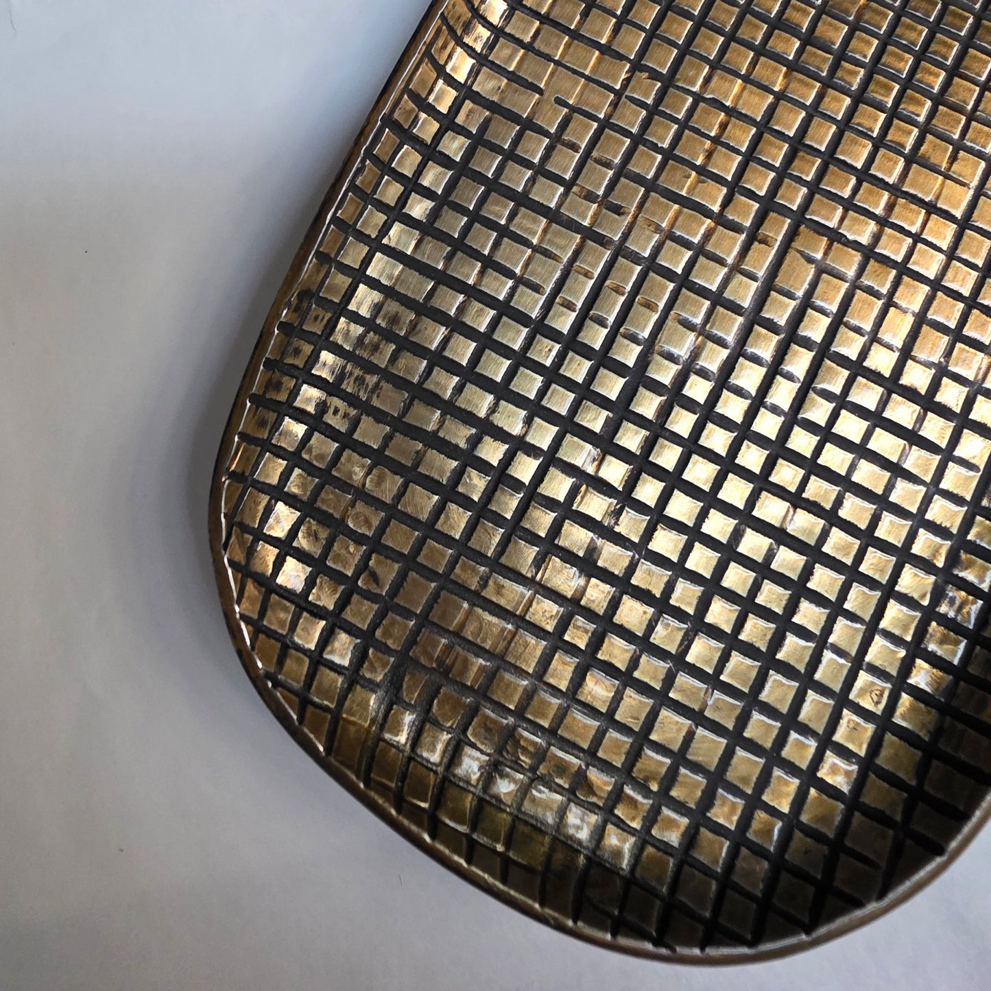 Metallic grid-patterned tray on a white background