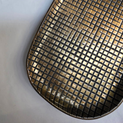 Metallic grid-patterned tray on a white background