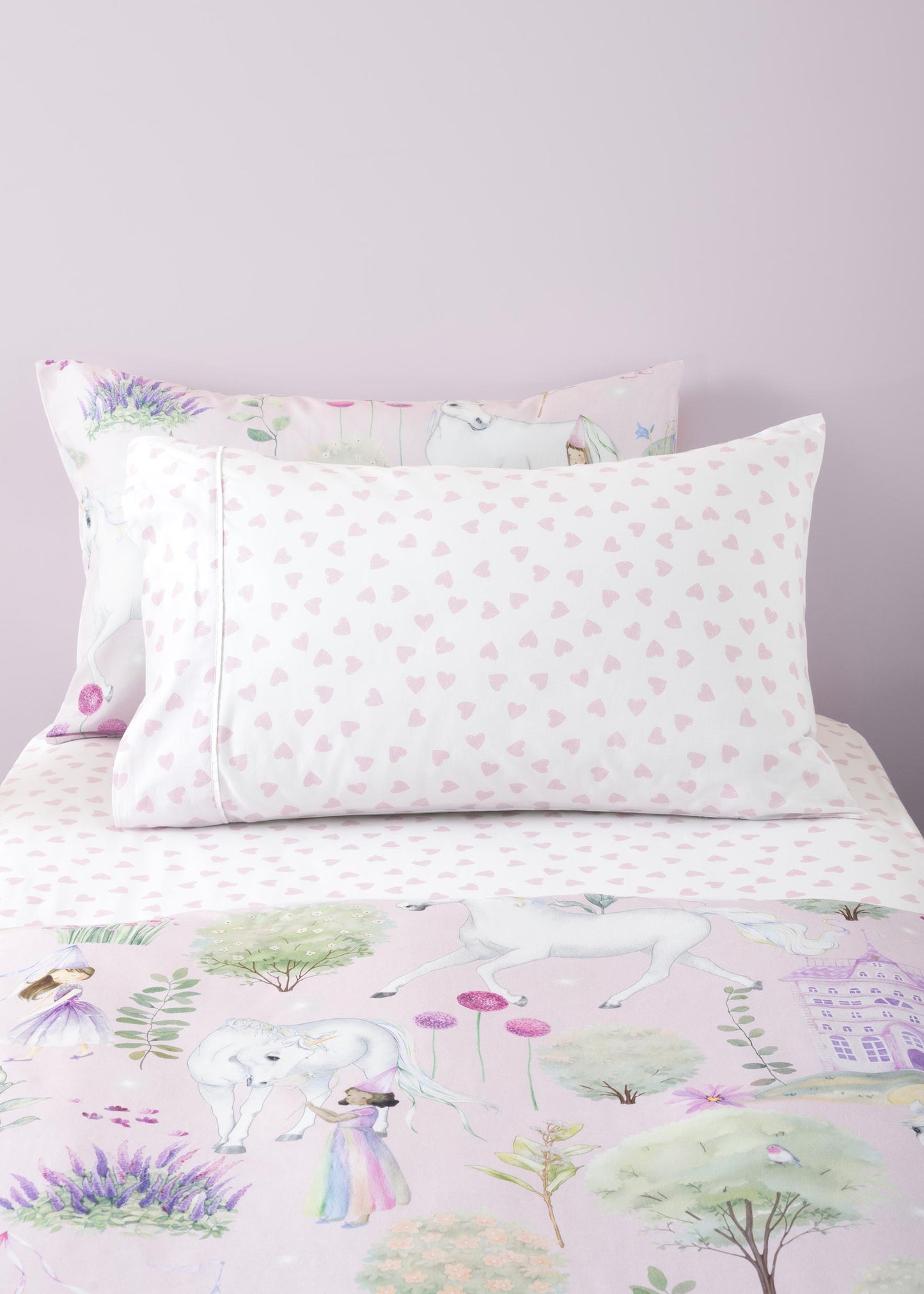 Floral and nature-themed bedding set with pillows on a bed.