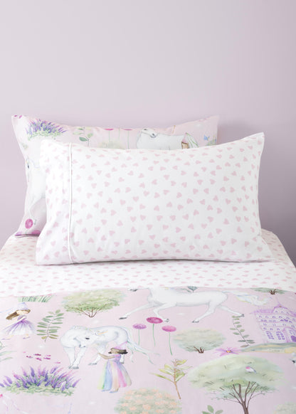 Floral and nature-themed bedding set with pillows on a bed.