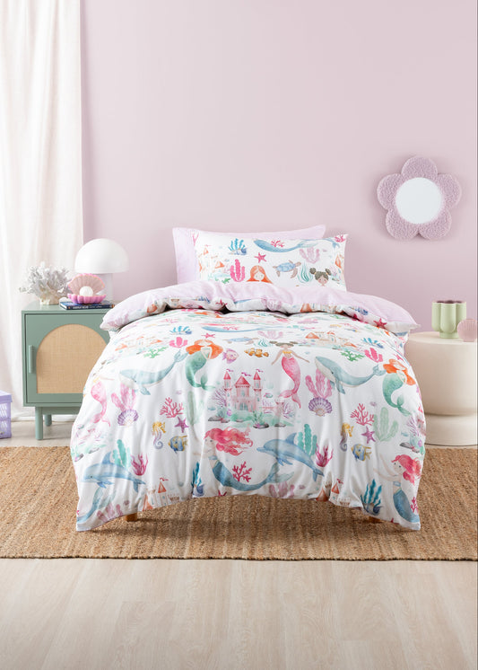 Bed with colorful floral comforter and pillows in a bedroom setting.