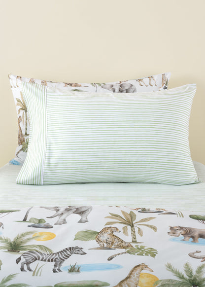 Striped pillow on a bed with a jungle-themed bedspread