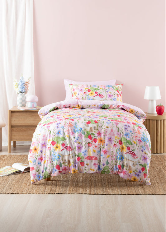 Floral bedding set on a bed in a bedroom with a pink wall.
