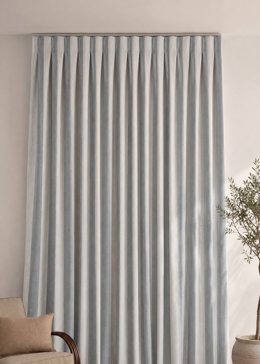 Striped curtain in a living room setting with a couch and decor items.
