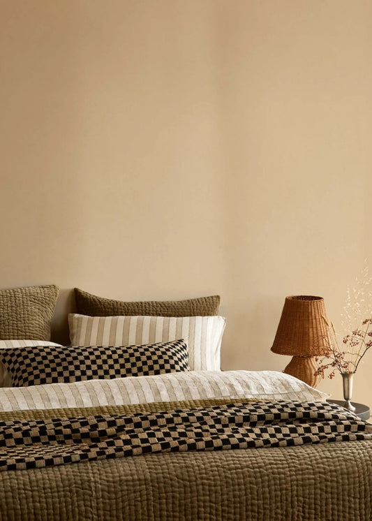 Cozy bedroom with a bed, lamp, and window.
