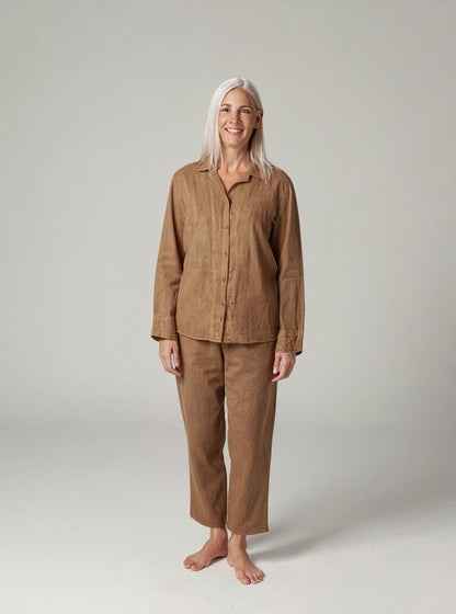 Person wearing a brown linen pajama set on a plain background