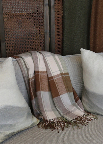 Plaid blanket draped over a chair with pillows