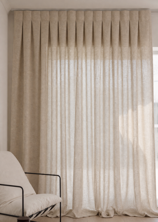 Beige curtains with a chair and coffee table in a room.