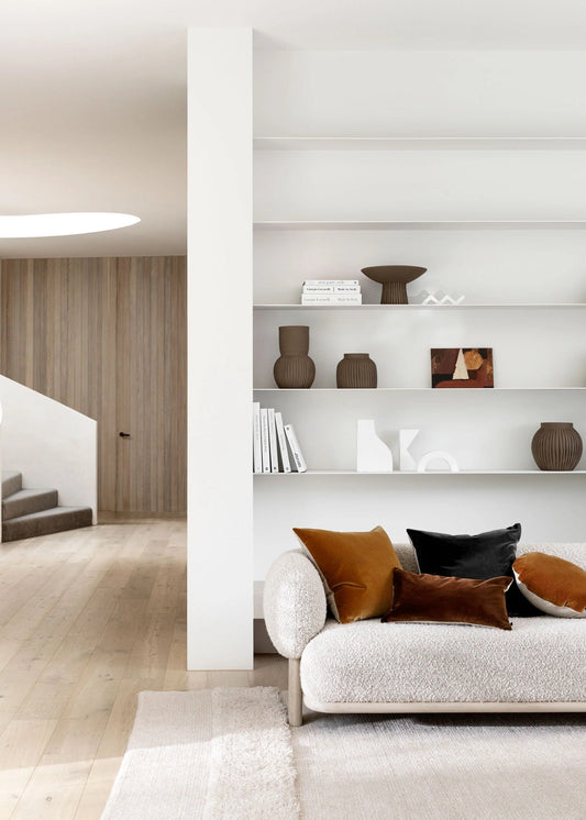Modern living room with a sofa, bookshelf, and decorative items.