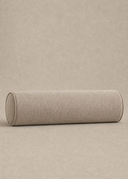 A cylindrical bolster pillow with a textured beige linen fabric cover, resting horizontally on a matching beige textured background.