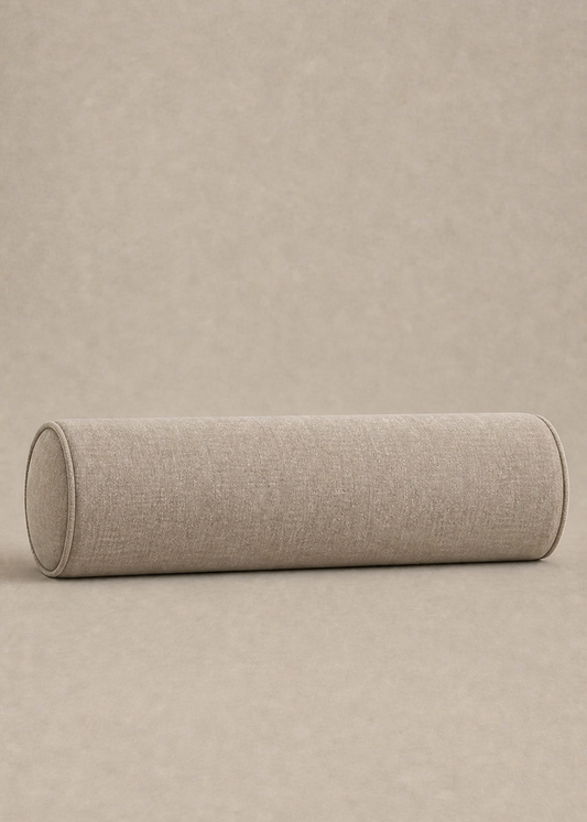 A cylindrical bolster pillow with a textured beige linen fabric cover, resting horizontally on a matching beige textured background.
