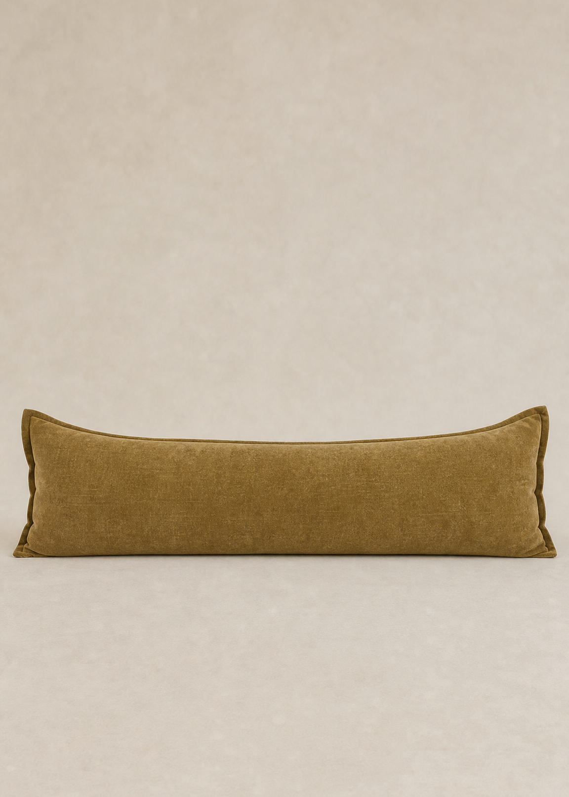 Long rectangular brown pillow on a beige background