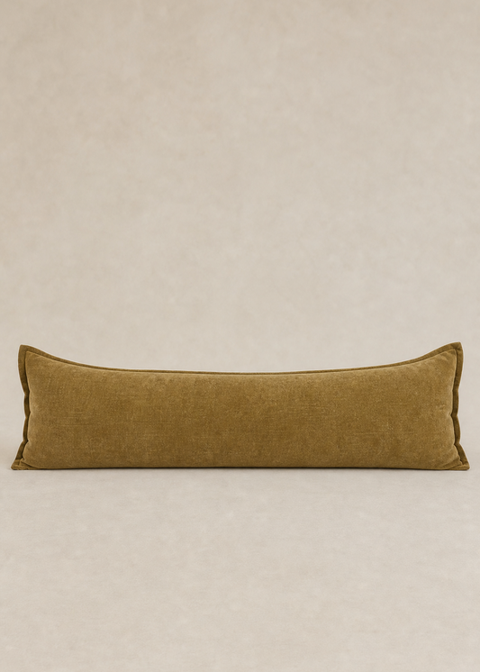 Long rectangular brown pillow on a beige background
