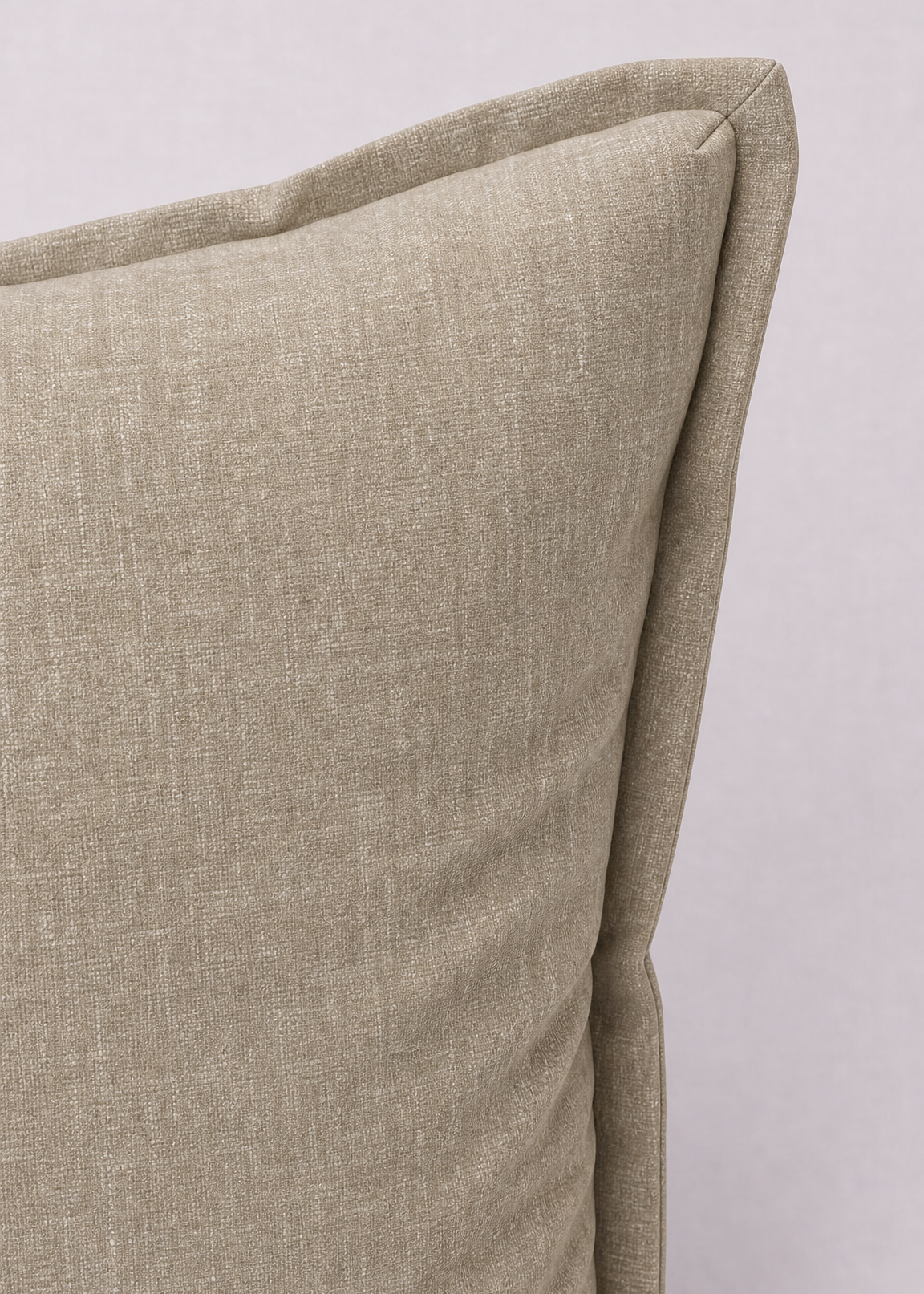 A close-up of a textured linen throw pillow in a light beige color, showing the corner seam and fabric weave against a neutral light gray background.