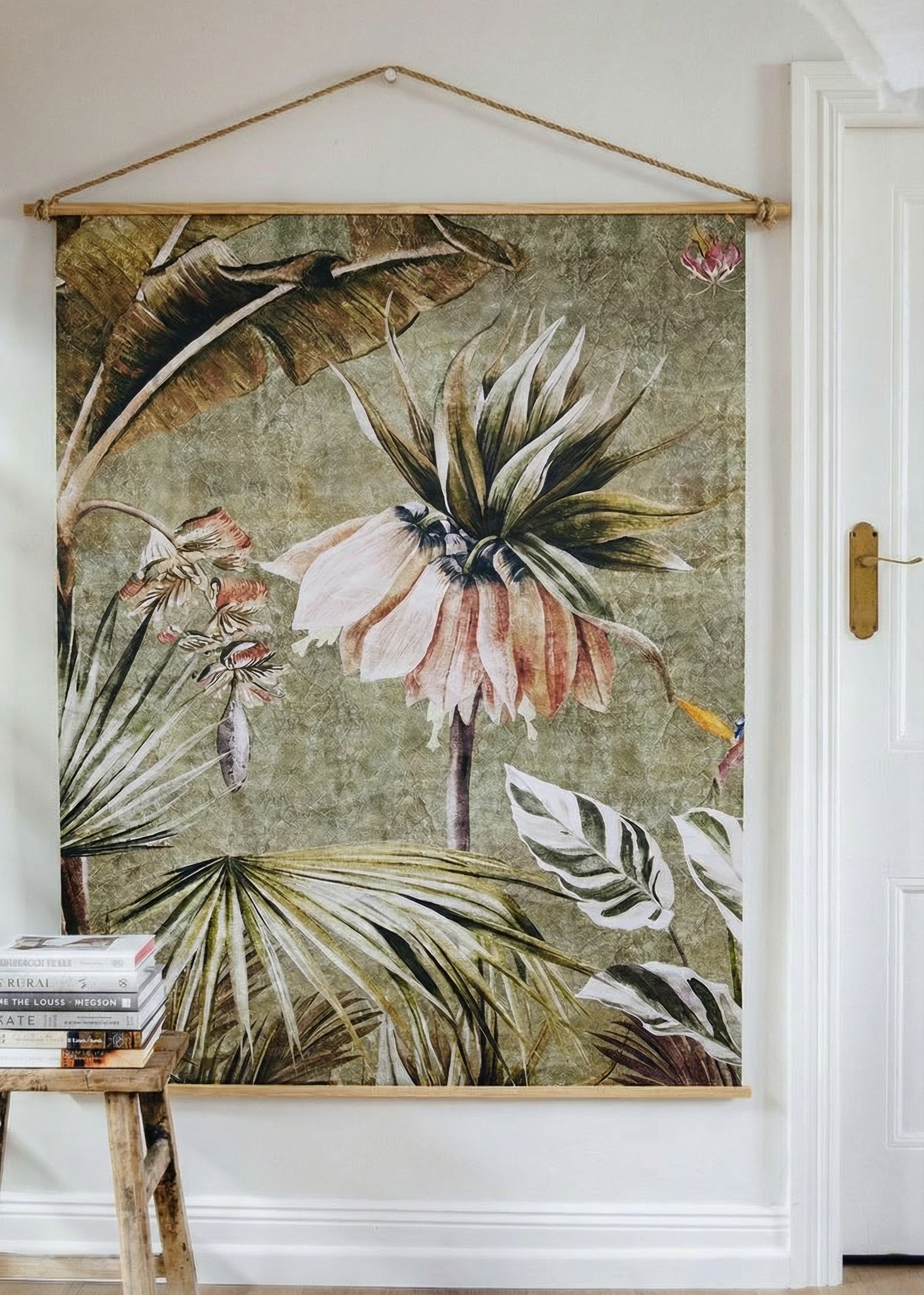 Floral tapestry hanging on a wall in a room with a wooden bench.