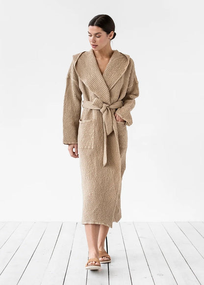 Woman wearing a beige robe on a white wooden floor