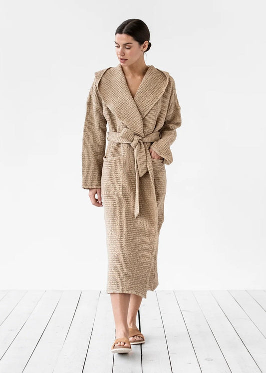 Woman wearing a beige robe on a white wooden floor