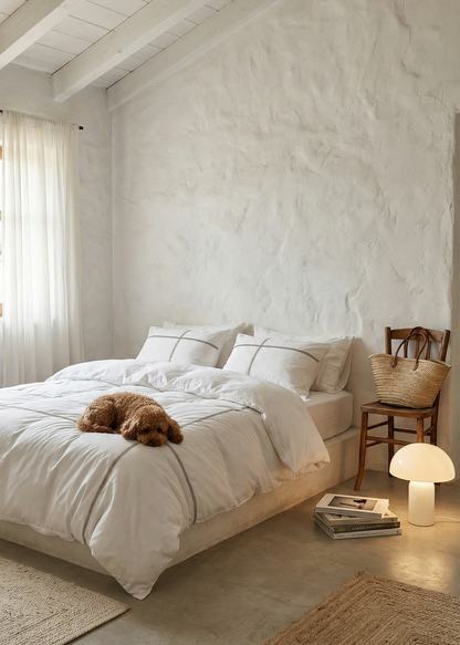 Cozy bedroom with a dog lying on the bed, wooden chair, and lamp.