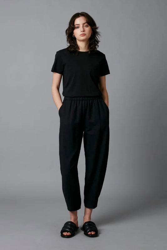 Woman wearing a black outfit against a gray background